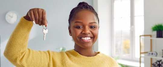 Excited Young Woman Tenant Renter Showing Key to New Apartment