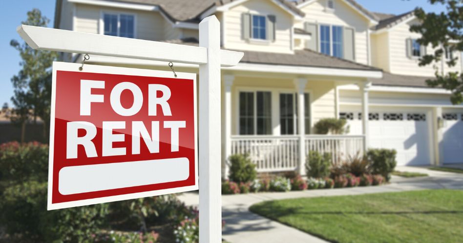 for rent real estate sign in front of house
